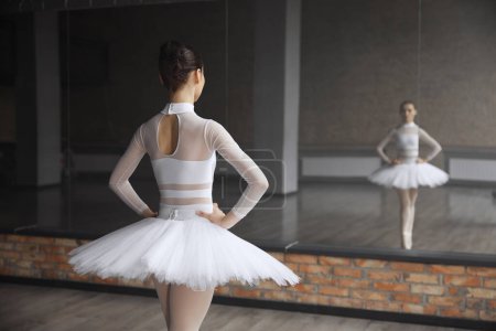Téléchargez les photos : Ballerine inquiète debout près d'un immense miroir au studio de danse avant la performance - en image libre de droit