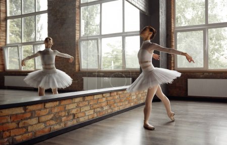 Téléchargez les photos : Belle jeune ballerine formation ballet classique en studio avec grand miroir. Concept de routine pratique - en image libre de droit