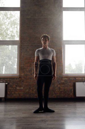 Téléchargez les photos : Portrait complet d'un beau danseur de ballet athlétique dans une salle de studio. Cours de formation pour métiers créatifs - en image libre de droit