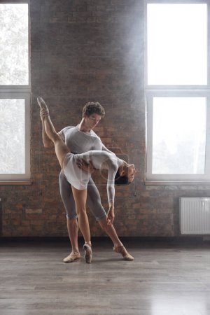 Foto de Bailarines de ballet contemporáneos pareja realizando coreografía elegante en clase de escuela de arte - Imagen libre de derechos