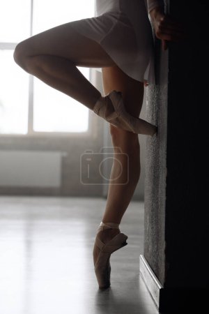 Foto de Vista de cerca de las piernas de la joven bailarina con zapatos puntiagudos. Práctica clásica de ballet en la escuela de danza - Imagen libre de derechos