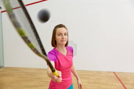 Photo for Closeup view on female athlete with racquet playing squash exercising at fit club. Recreational pursuit on weekend concept - Royalty Free Image