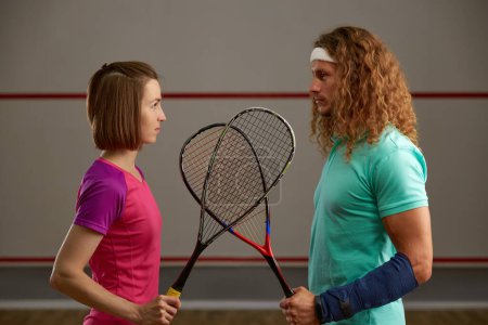 Téléchargez les photos : Confrontation entre joueurs de squash masculins et féminins sur le concept du court. L'homme et la femme dans le sport professionnel concept d'égalité - en image libre de droit