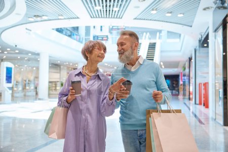 Foto de Pareja mayor adulta con compras en bolsas que se divierten en el centro comercial. Fines de semana en concepto de jubilación - Imagen libre de derechos