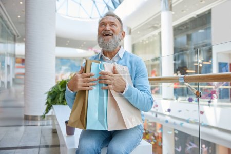 Photo for Happy fashion elderly man with purchases in shopping mall - Royalty Free Image