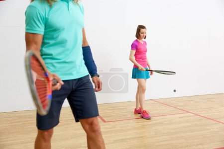 Foto de Recorte de tiro de atleta masculino en ropa deportiva jugando al squash en el gimnasio deportivo interior. concepto de estilo de vida saludable - Imagen libre de derechos
