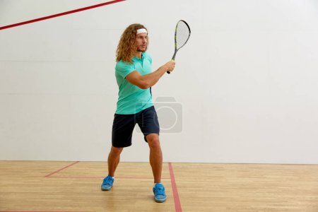 Photo for Male athlete in sportswear playing squash training at indoor sportive fitness club. Healthy lifestyle concept - Royalty Free Image