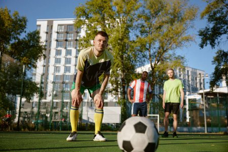 Photo for Pensive soccer player thinking trying to score penalty goal. Friends athlete playing football on city stadium together - Royalty Free Image