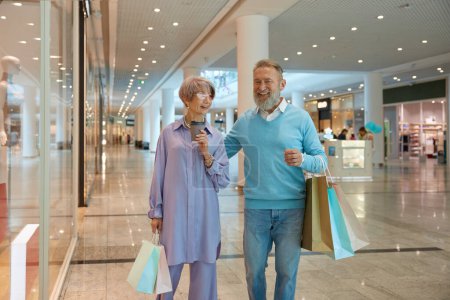 Photo for Overjoyed senior couple with shopping bags rejoicing successful purchases during Black Friday sale - Royalty Free Image