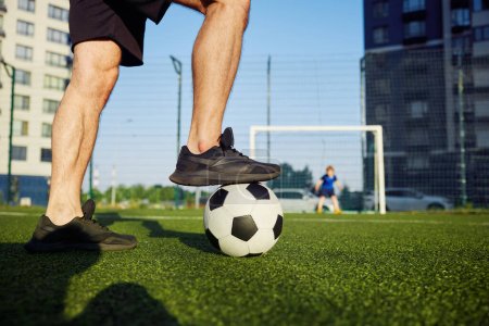 Photo for Family playing football on field. Focus on father foot on soccer ball. Dad preparing to hit goal, son defending gate - Royalty Free Image