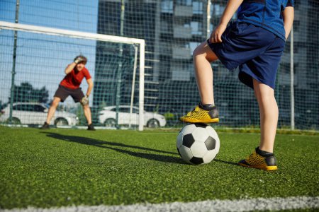 Photo for Father goal keeper and schoolboy son forward training football at stadium. Active family having fun outdoors enjoying sport leisure time - Royalty Free Image