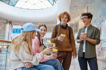 Photo for Group of children spending recreation fun weekend time together drinking coffee at shopping mall. Girls and boys laughing having nice conversation - Royalty Free Image