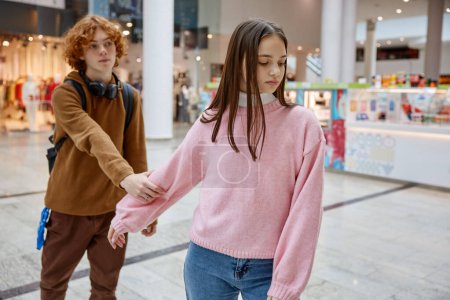 Foto de Pareja adolescente peleando durante la cita en el centro comercial. Incomprensión entre los jóvenes - Imagen libre de derechos