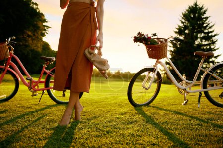 Photo for Closeup barefoot young female bicyclist on park grass lawn. Healthy lifestyle, active leisure time and unity with nature concept - Royalty Free Image