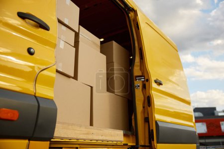 Photo for Closeup opened mini van doors and cardboard parcel boxes inside. Express freight transport shipping service - Royalty Free Image