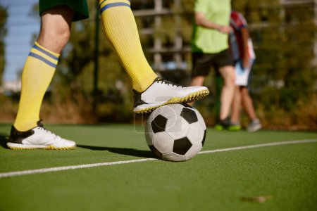 Foto de Primer plano pie masculino en botas en pelota de fútbol sobre hierba verde fondo del campo. Actividades deportivas al aire libre para adultos - Imagen libre de derechos