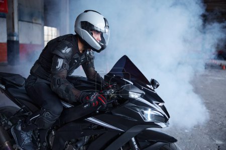 Téléchargez les photos : Le motard portant le casque protecteur et l'uniforme pour la vitesse à la classe d'entraînement du motodrome de l'école de conduite professionnelle - en image libre de droit