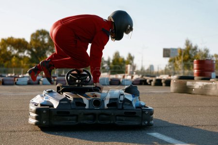 Foto de Hombre excitado conductor saltando en go-cart preparándose para el entretenimiento de carreras de velocidad. Concepto de hobby masculino - Imagen libre de derechos