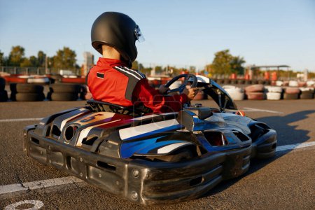 Photo for Diver racing on go-cart track outdoors enjoying competitive activity. Carting recreational pursuit challenge - Royalty Free Image