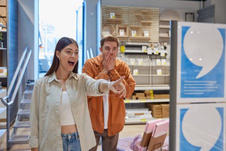 Photo for Excited young couple rejoicing seeing great price clearance and discounts at modern furniture shop store department. Shopping with sale, Black Friday or Christmas wholesale concept - Royalty Free Image