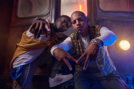 Téléchargez les photos : Deux types émotionnels jouant du hip-hop en underground. Les jeunes sont fous de rap - en image libre de droit