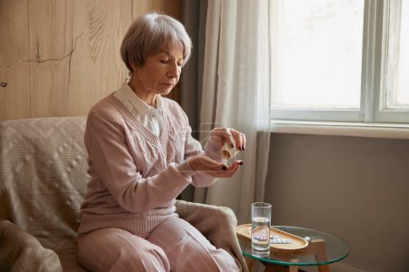 Foto de Señora anciana tomando píldoras de enfermedades crónicas, suplemento dietético o multivitaminas para la salud y la belleza anti-edad - Imagen libre de derechos