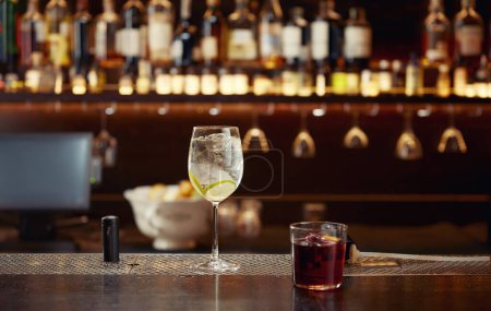 Téléchargez les photos : Cocktail avec glace et citron sur comptoir de bar en bois. Boisson chère pour le client, meilleur service de luxe à la boîte de nuit ou au restaurant - en image libre de droit