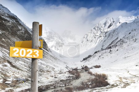Photo for 2023 written on yellow postsign  on mountain in snow background - Royalty Free Image