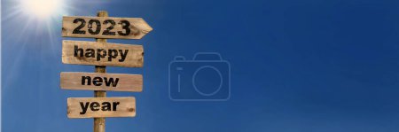 Photo for 2023 happy new year writting on a wooden postsign on sunny blue sky - Royalty Free Image