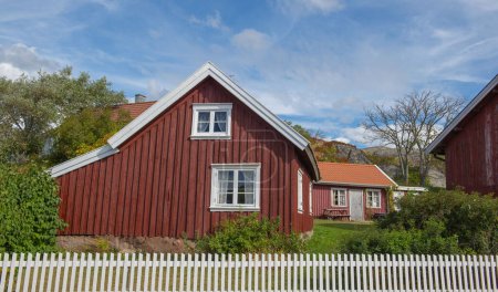 casa típica roja con cerca blanca en frente en un pueblo sueco 