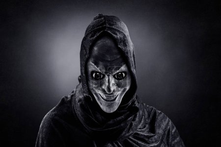 Photo for Scary figure with hooded cloak in the dark - Royalty Free Image