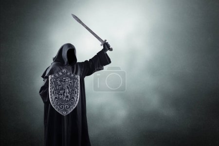 Photo for Dark knight with sword and shield over dark misty background - Royalty Free Image