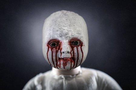 Photo for Creepy bloody doll over dark misty background - Royalty Free Image
