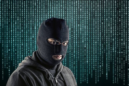 Criminal vistiendo pasamontañas negro y sudadera con capucha sobre fondo azul código informático