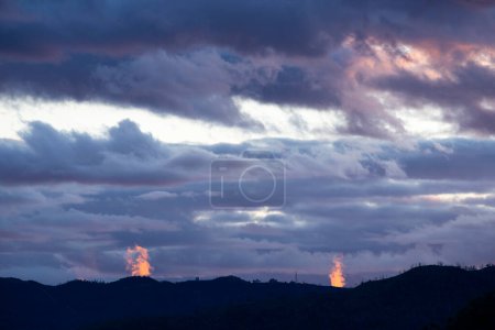 Foto de Cielo nublado con dos géiseres retroiluminados por el sol poniente. - Imagen libre de derechos