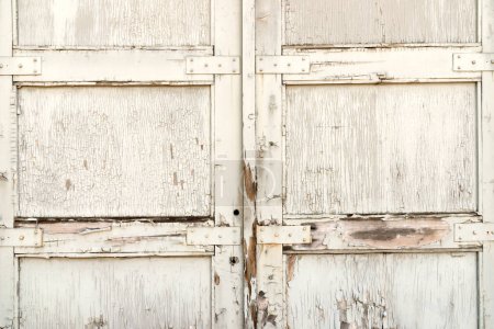 Foto de Pintura envejecida blanca en puertas de madera con bisagras. - Imagen libre de derechos