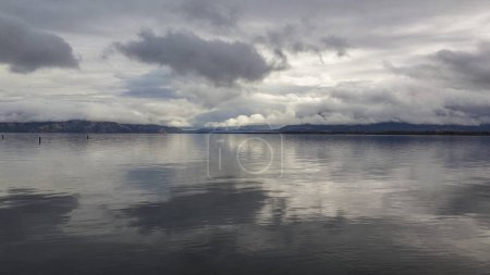 Foto de Large lake with clouds reflecting into the still water - Imagen libre de derechos