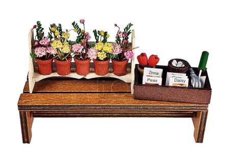 A gardening bench with potted flowers, seeds and gardening tools