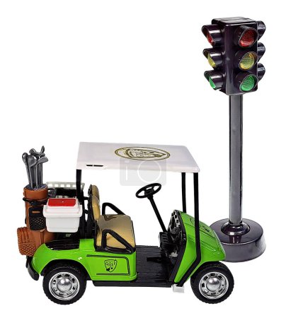 A golf cart used for transportation during a game of golf and a traffic light to show safety while playing