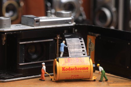 Photo for Miniature Workmen Handling Vintage Film and Cameras - Royalty Free Image