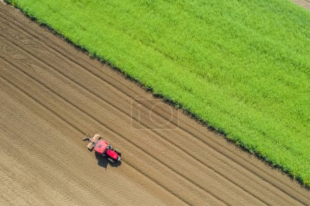 Foto de Vista aérea de un tractor arando tierra seca en primavera - Imagen libre de derechos