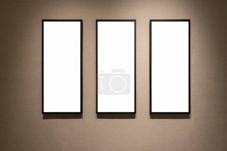 Téléchargez les photos : Trois cadres vierges sur un mur avec papier peint, chemin de coupe comprend - en image libre de droit