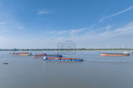Foto de Concurrida escena de transporte de agua y parque eólico del banco de arena del río Yangtze contra un cielo azul - Imagen libre de derechos