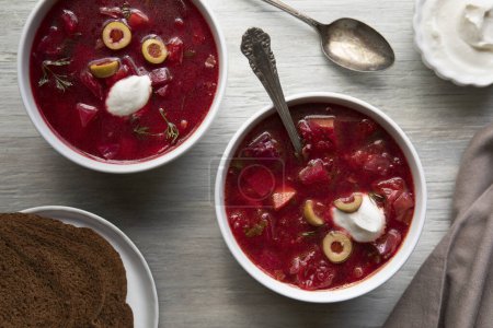 Téléchargez les photos : Deux bols de soupe au chunky bortsch garnis d'olives vertes et de crème sure - en image libre de droit