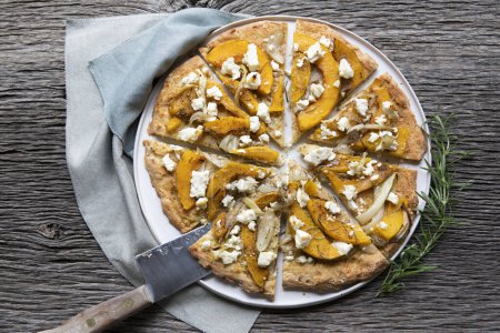 Téléchargez les photos : Pizza rustique à la courge d'hiver avec oignon, courge musquée, romarin, sauge, fromage feta - en image libre de droit