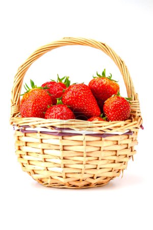 Foto de Fresas rojas maduras en una pequeña canasta de mimbre. Enfoque selectivo con profundidad de campo poco profunda. - Imagen libre de derechos