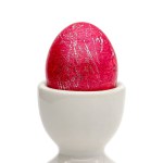 Easter egg dyed red according to the religious holiday. Selective focus with shallow depth of field.