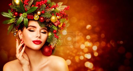 Photo for Christmas Woman Beauty. Beautiful Girl in Fir Tree Wreath with Xmas Ornaments Decor. Women Face Skin and Hands Winter Care. Fashion Model with Red Lips over Fantasy Shining Background - Royalty Free Image