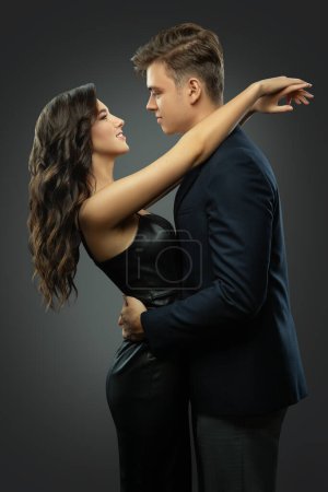 Photo for Couple in Love looking at each other side view. Happy Girl embracing Handsome Boy on Dating. Romantic Man and Woman Face profile over Gray. Betrothed Couple Hugging - Royalty Free Image