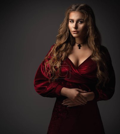 Téléchargez les photos : Robe Fantaisie Princesse en Velours Rouge. Portrait de dame médiévale sur fond noir. Mystérieuse belle femme dans la robe vintage de luxe - en image libre de droit